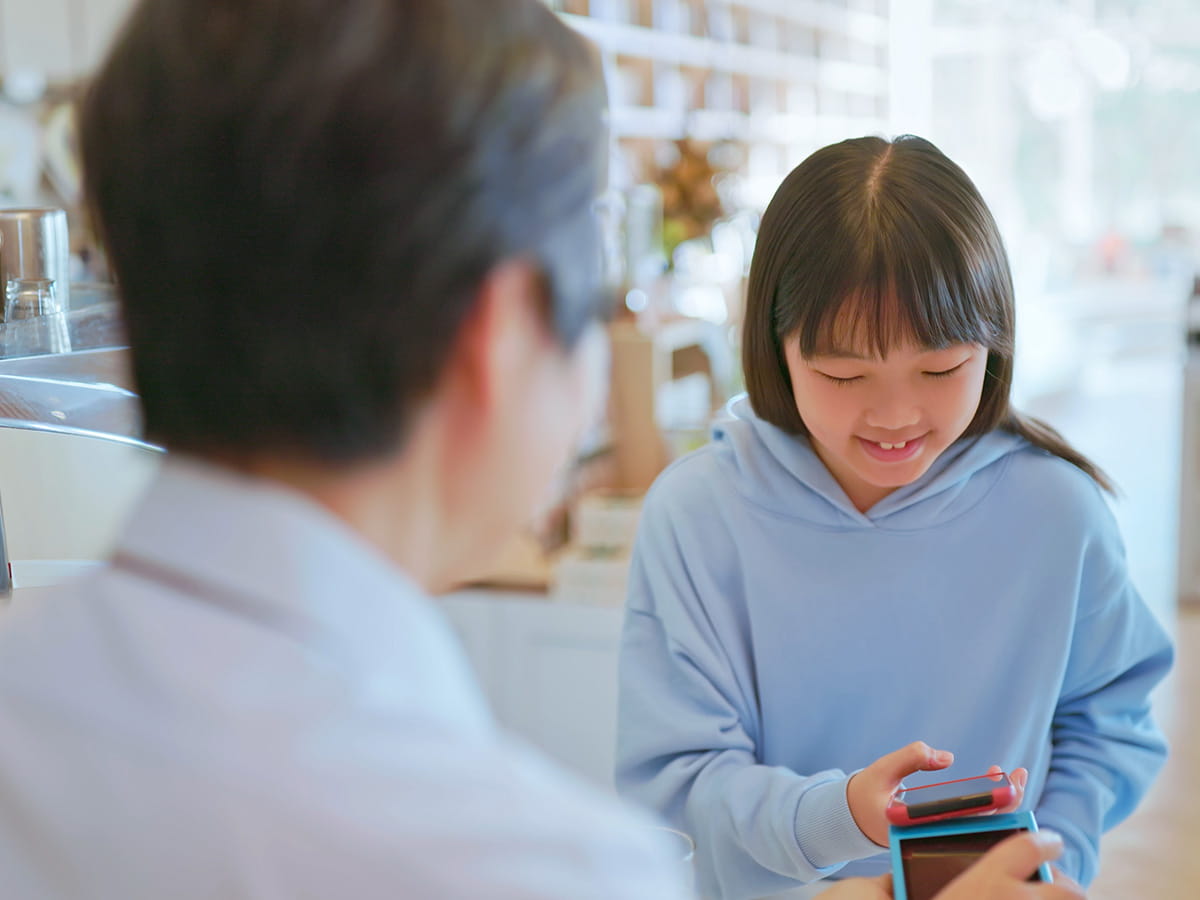 A young girl making a payment at a store