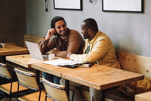 A couple working on a laptop at a coffee shop