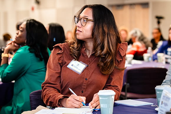 Woman taking notes at a presentation