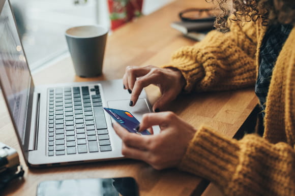 Someone on a laptop using a Citadel Credit Card