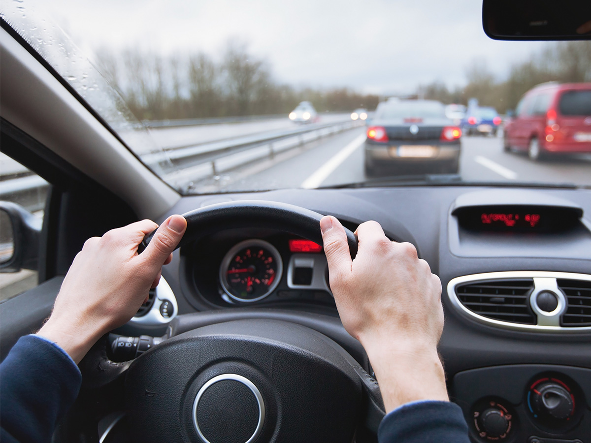 Someone driving a car from the drivers perspective 