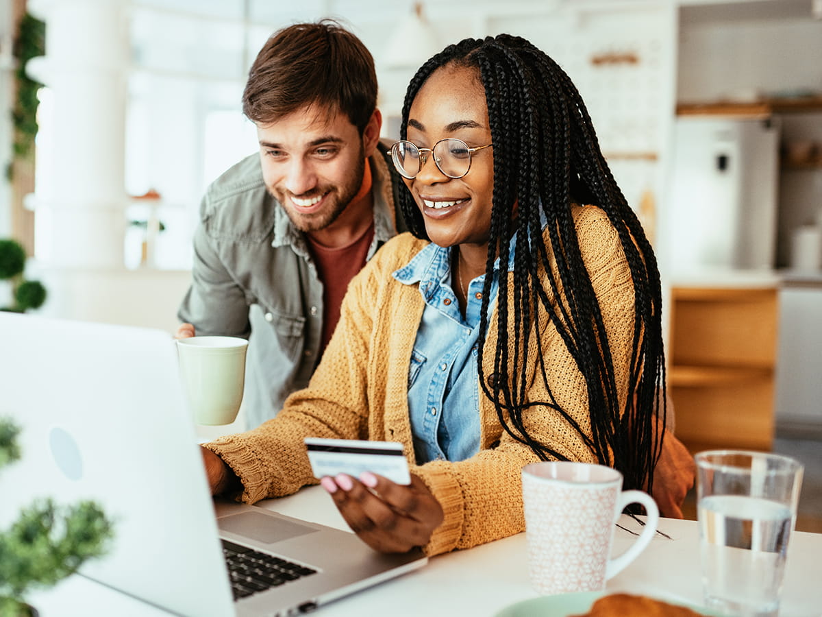 Two people making a purchase on a laptop at home