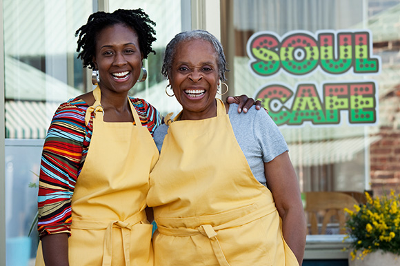 2 women standing in from of their restaurant